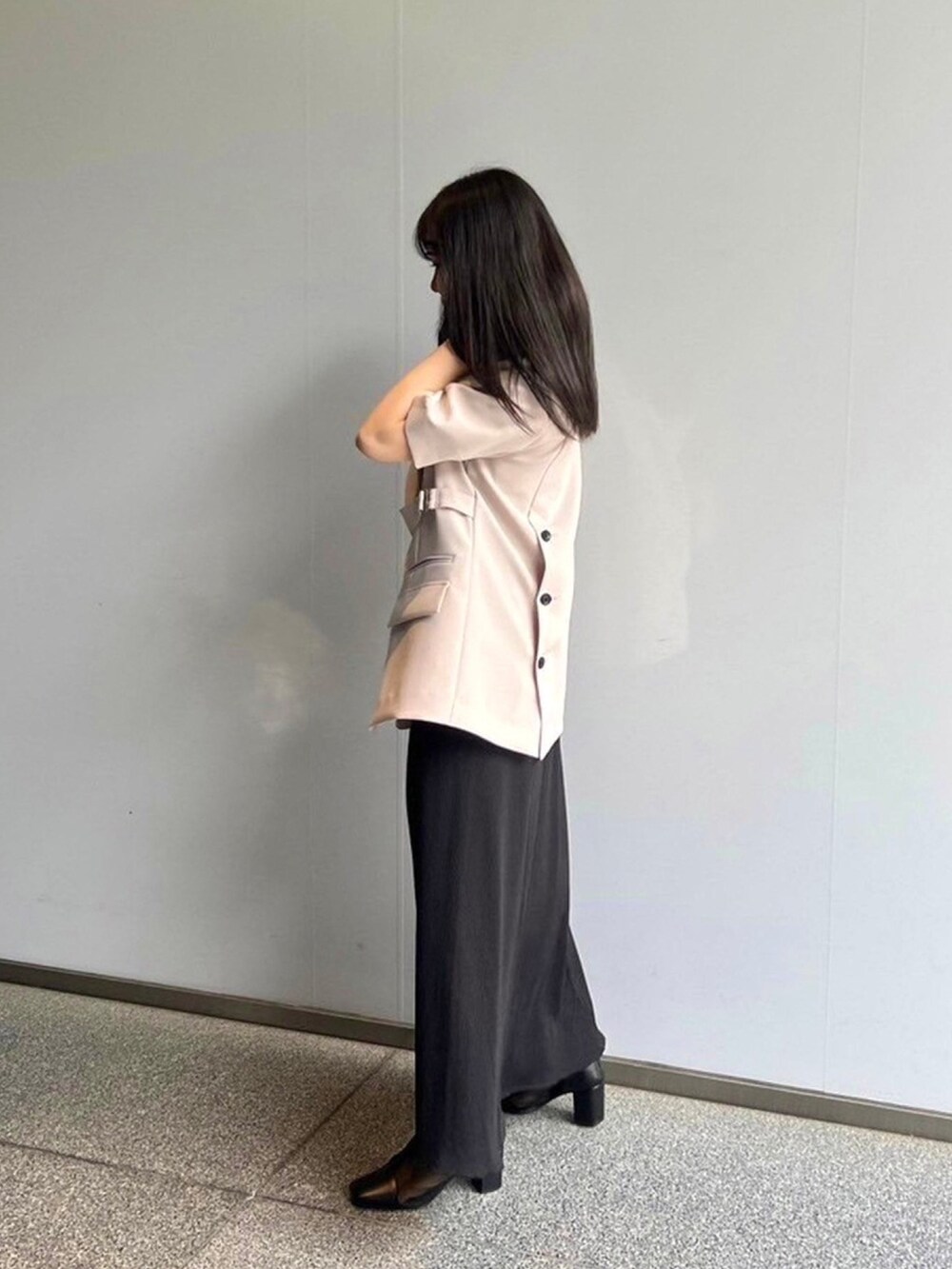 ベージュ系のテーラードジャケット、ブラック系のワンピースを着用したレディースの春コーディネートの2枚目の写真