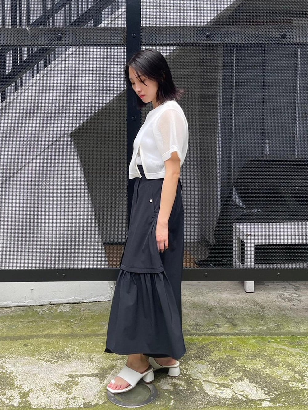 ホワイト系のタンクトップ、ホワイト系のシャツ/ブラウス、ブラック系のスカートを着用したレディースの春コーディネートの2枚目の写真
