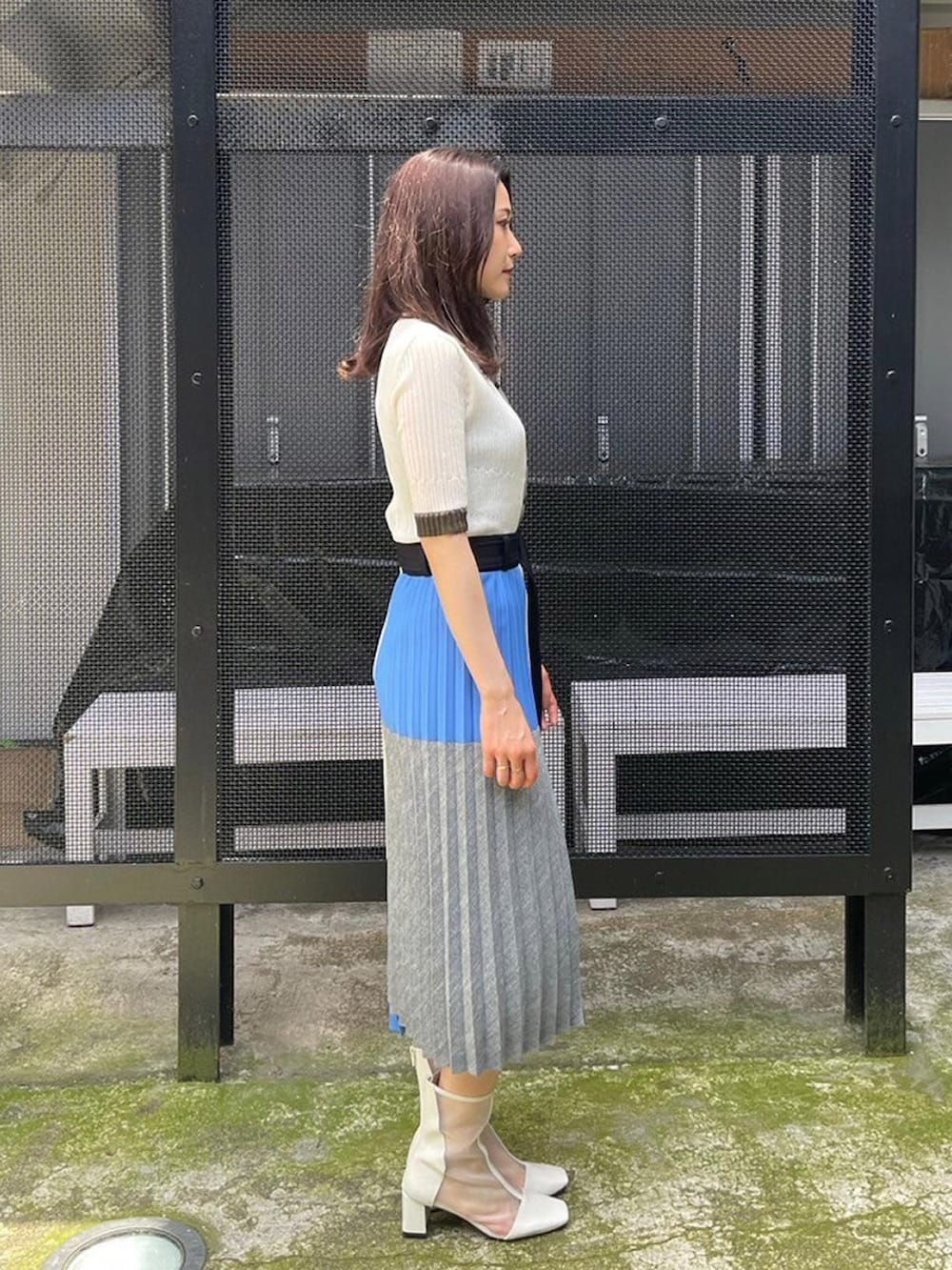 ブルー系のスカート、ホワイト系のニット/セーターを着用したレディースの春コーディネートの2枚目の写真