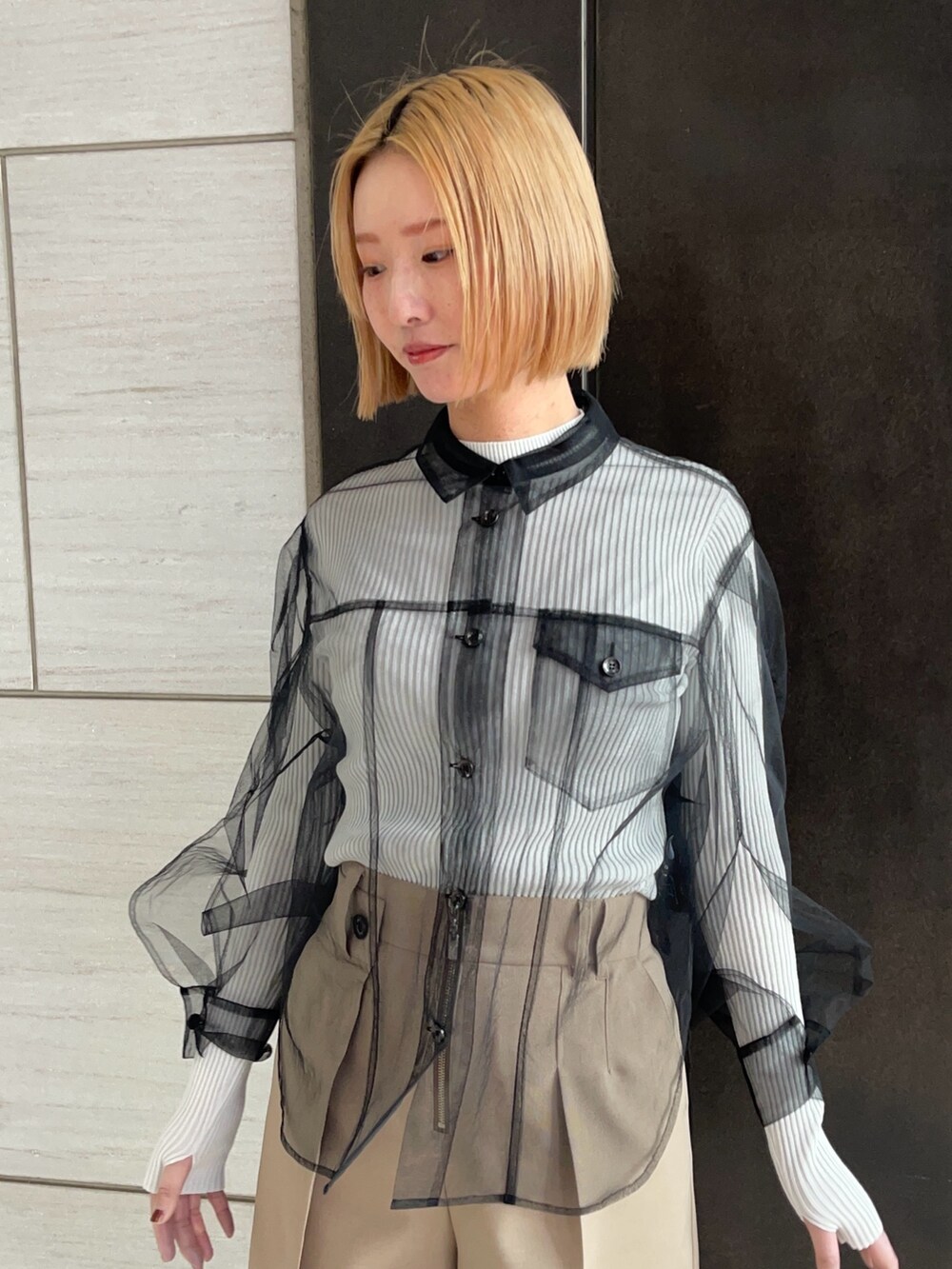 ブラック系のシャツ/ブラウス、ホワイト系のニット/セーター、ベージュ系のその他パンツを着用したレディースの春コーディネートの5枚目の写真