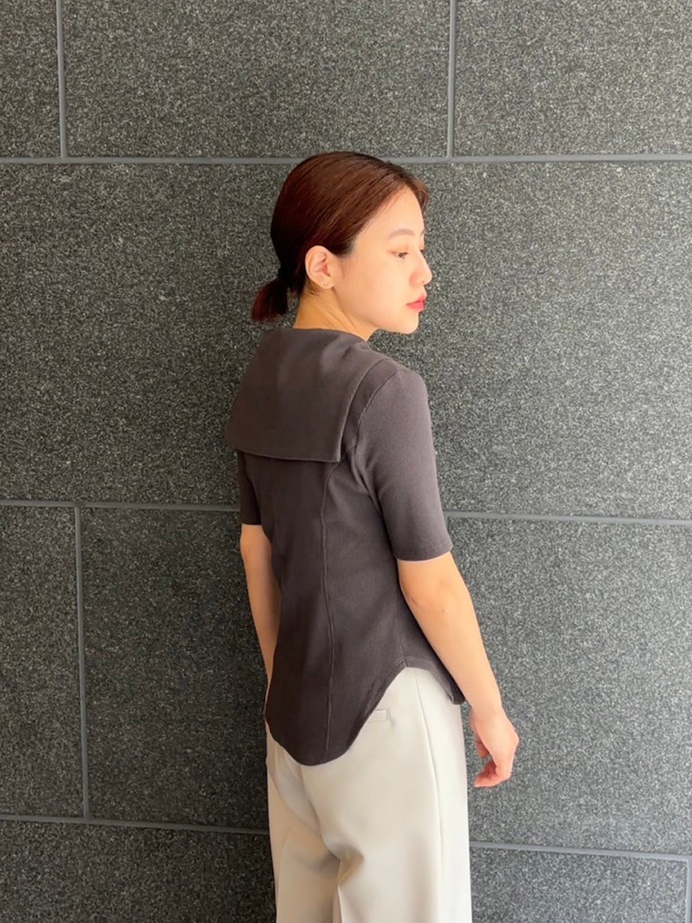 グレー系のTシャツ/カットソー、グレー系のスラックスを着用したレディースの夏コーディネートの3枚目の写真