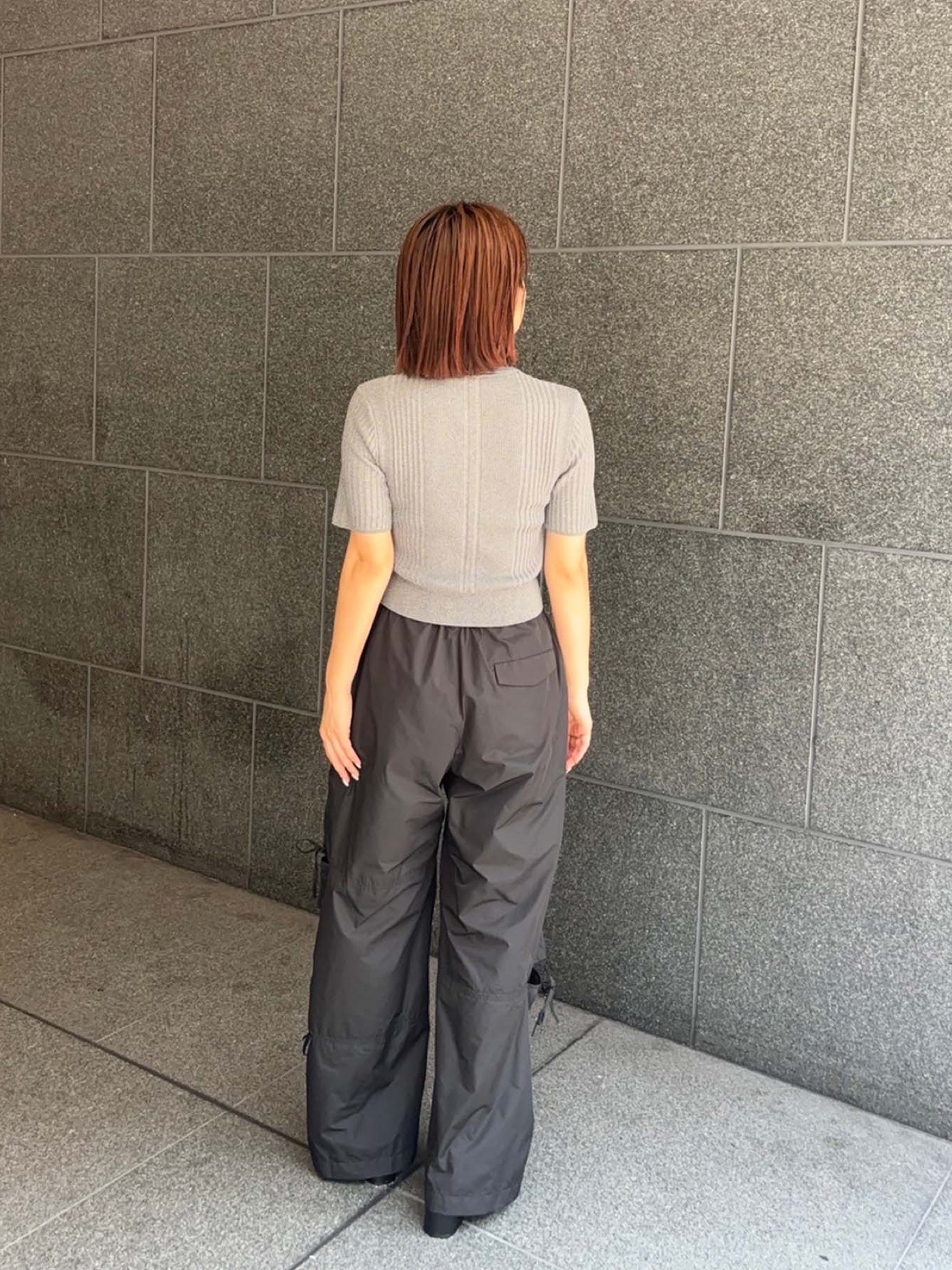 グレー系のポロシャツ、ブラック系のその他パンツを着用したレディースの夏コーディネートの3枚目の写真