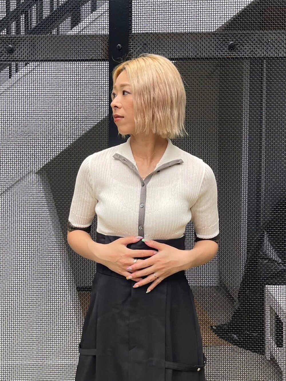 ホワイト系のニット/セーター、ブラック系のスカートを着用したレディースの夏コーディネートの5枚目の写真