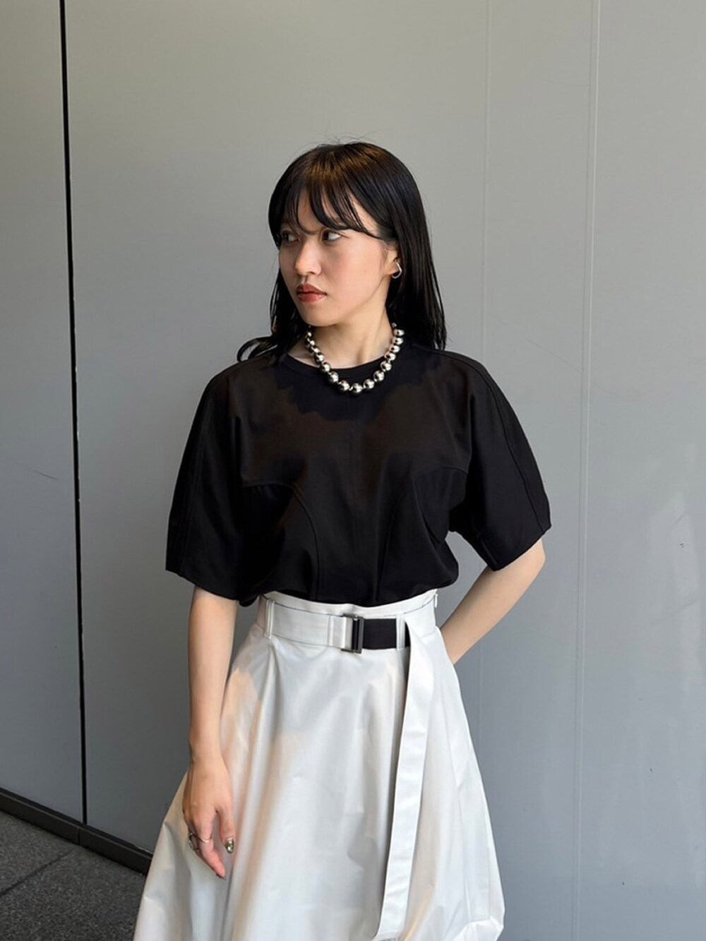 ブラック系のTシャツ/カットソー、ホワイト系のスカートを着用したレディースの夏コーディネートの3枚目の写真