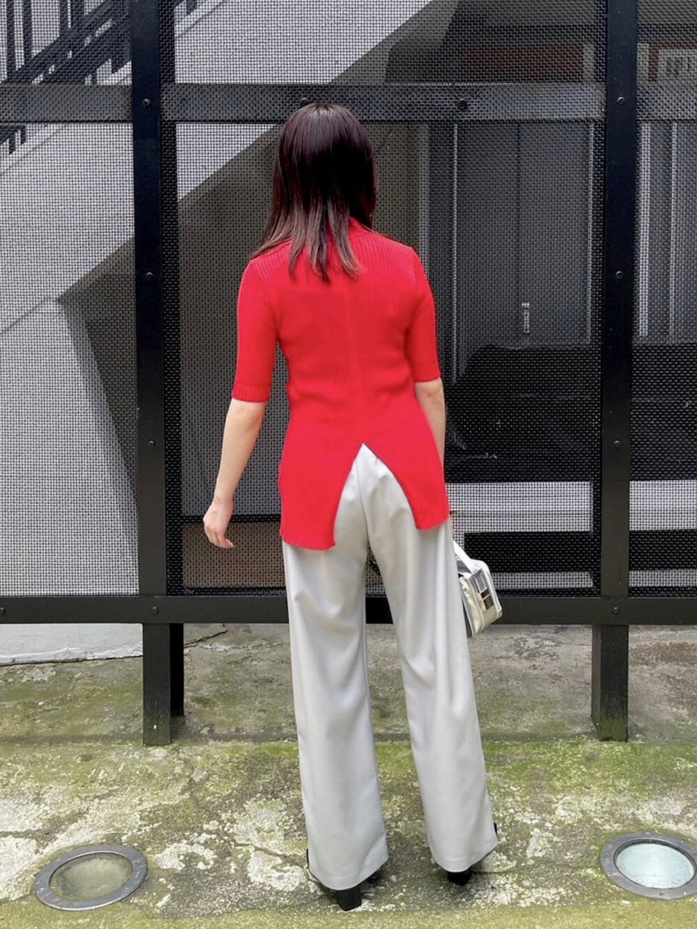 グレー系のその他パンツ、レッド系のニット/セーターを着用したレディースの春コーディネートの3枚目の写真