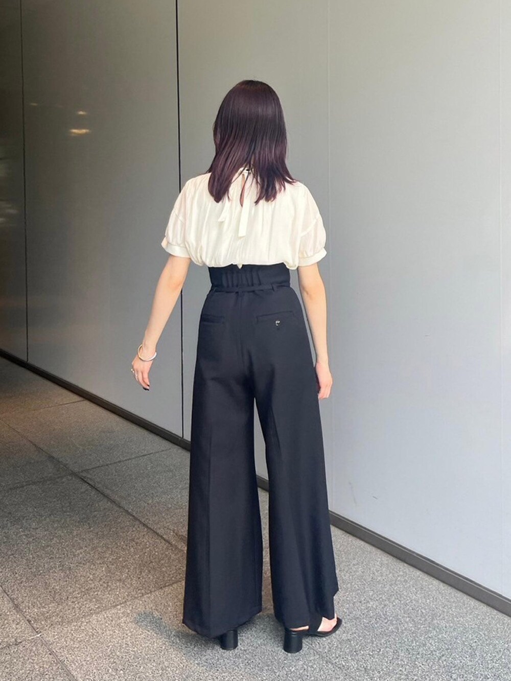 ベージュ系のシャツ/ブラウス、ブラック系のスラックス、ブラック系のサンダルを着用したレディースの夏コーディネートの2枚目の写真