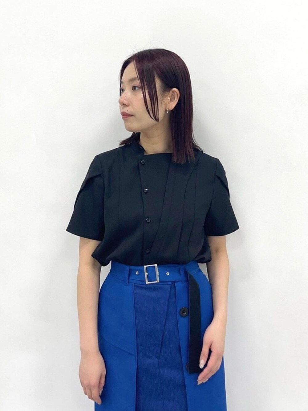 ブルー系のスカート、ブラック系のシャツ/ブラウスを着用したレディースの春コーディネートの5枚目の写真