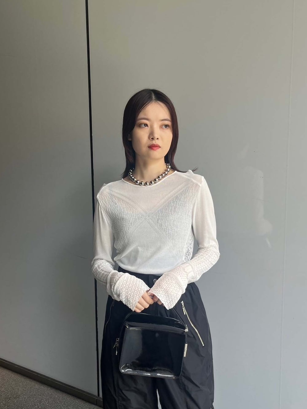 ホワイト系のニット/セーター、ブラック系のその他パンツを着用したレディースの夏コーディネートの4枚目の写真