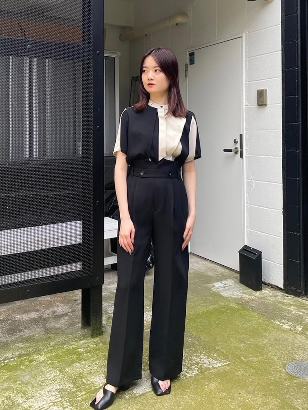 ベージュ系のシャツ/ブラウス、ブラック系のスラックスを着用したレディースの春コーディネートの2枚目の写真