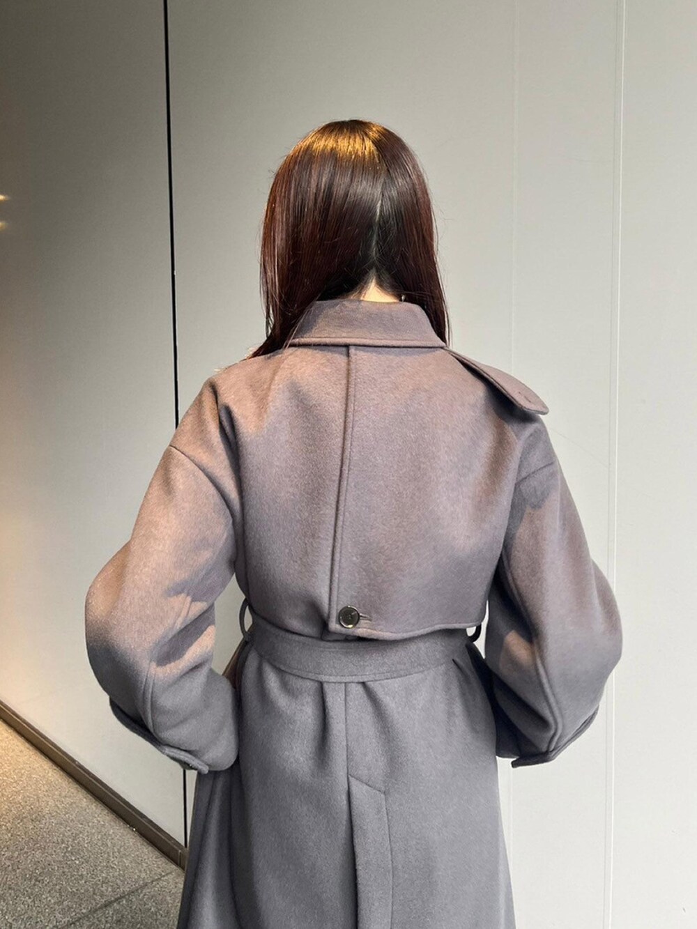 グレー系のステンカラーコートを着用したレディースの秋コーディネートの5枚目の写真