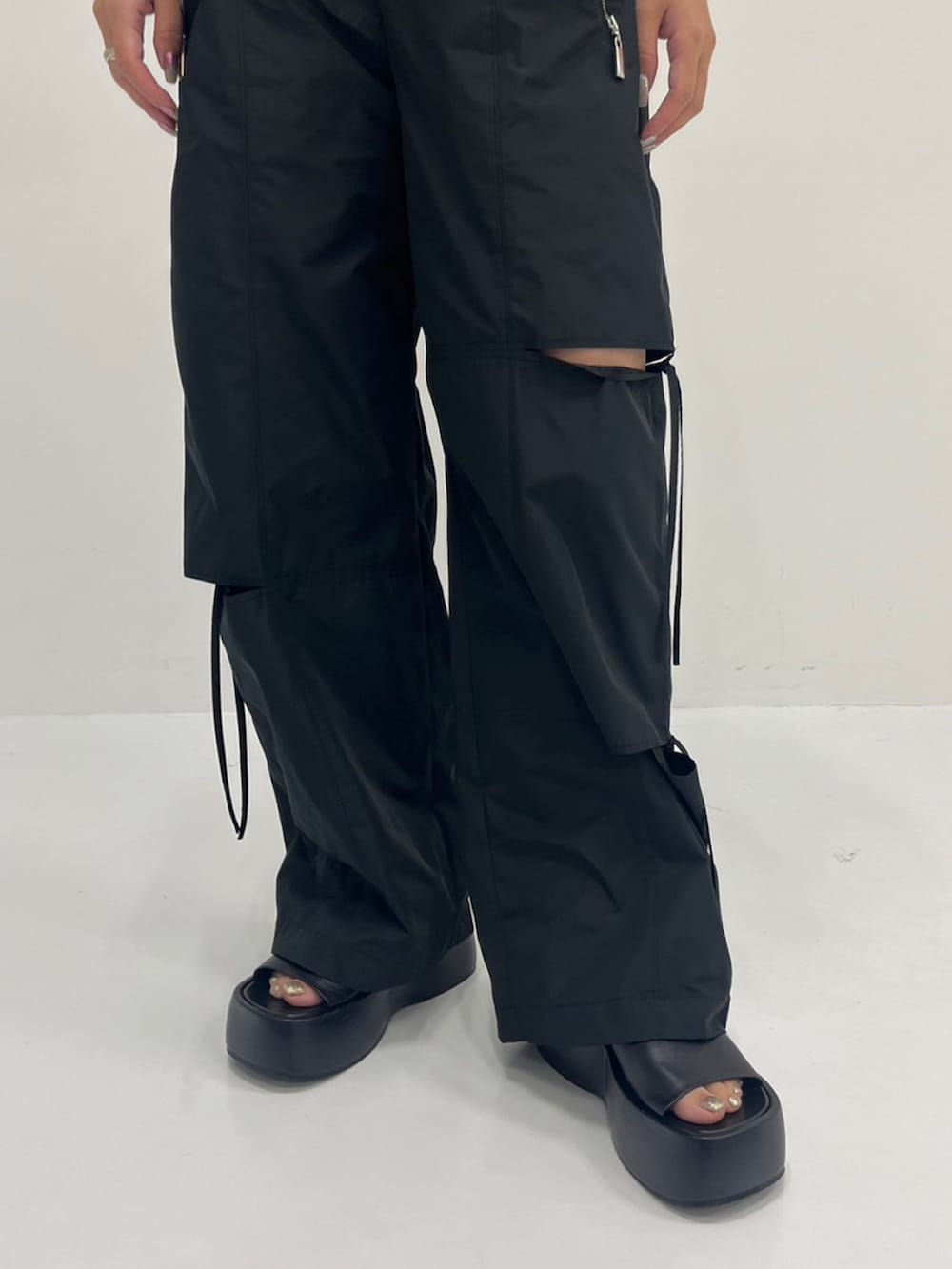 ブラック系のその他パンツ、グリーン系のシャツ/ブラウス、シルバー系のニット/セーターを着用したレディースの夏コーディネートの2枚目の写真