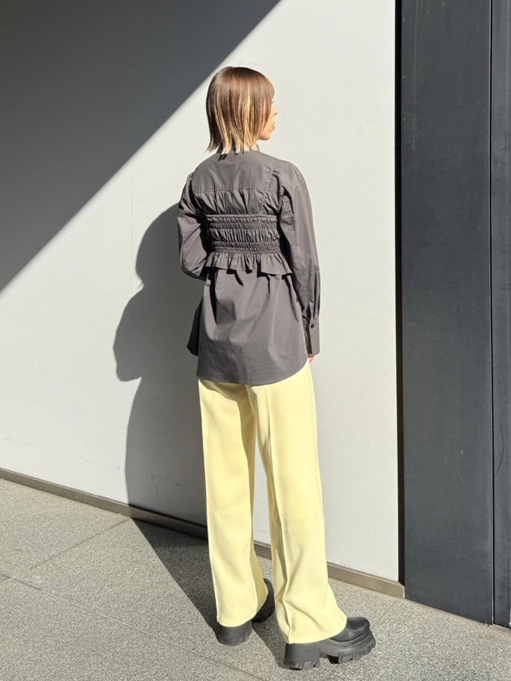 グレー系のシャツ/ブラウス、イエロー系のスラックスを着用したレディースの秋コーディネートの3枚目の写真