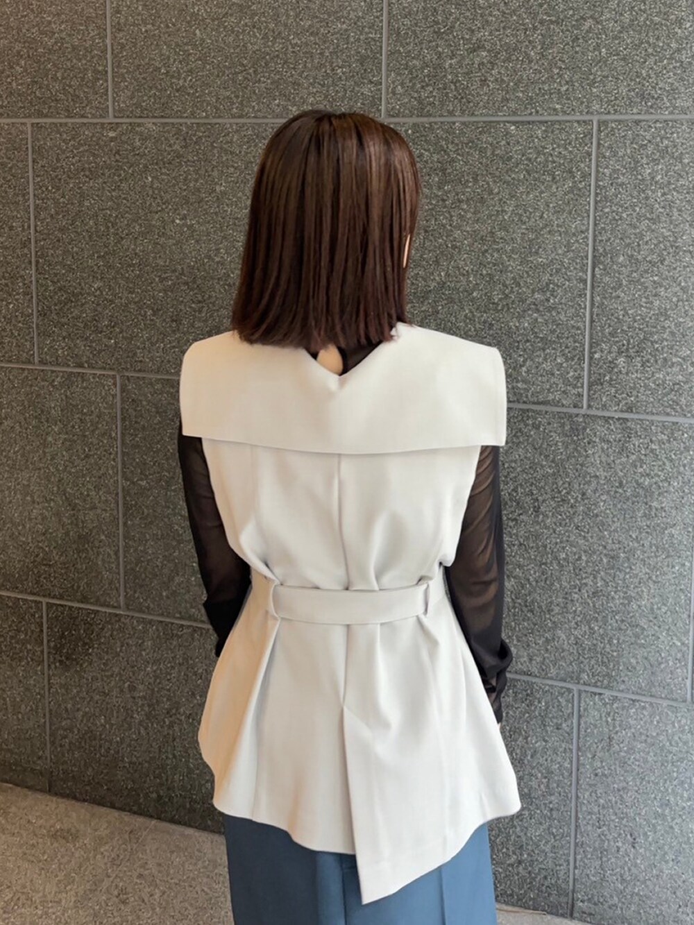 グレー系のテーラードジャケット、ブルー系のスカートを着用したレディースの秋コーディネートの4枚目の写真