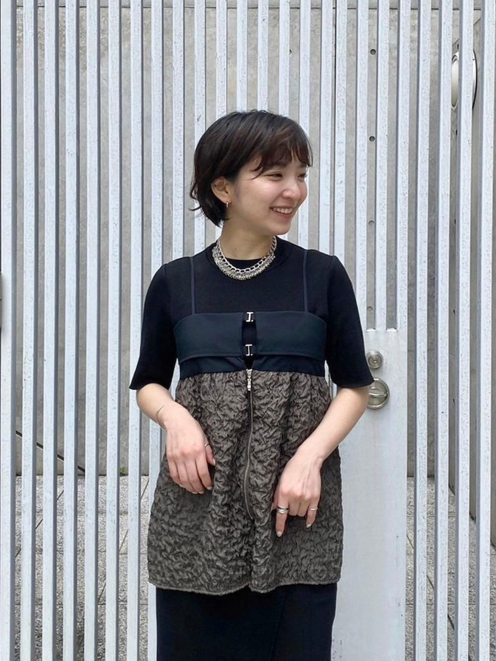 グリーン系のキャミソールを着用したレディースの春コーディネートの5枚目の写真