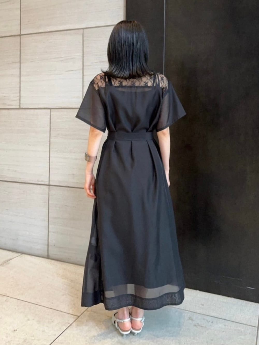 ブラック系のシャツワンピースを着用したレディースの春コーディネートの3枚目の写真
