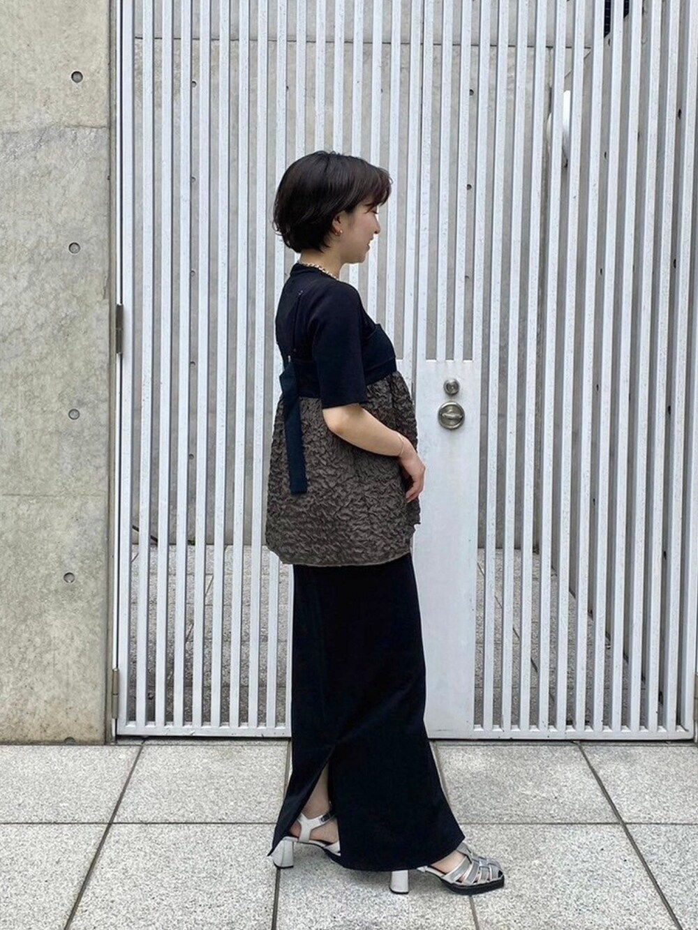 グリーン系のキャミソールを着用したレディースの春コーディネートの4枚目の写真