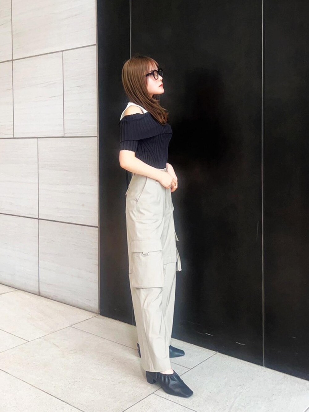 ベージュ系のカーゴパンツ、ブラック系のニット/セーターを着用したレディースの春コーディネートの4枚目の写真