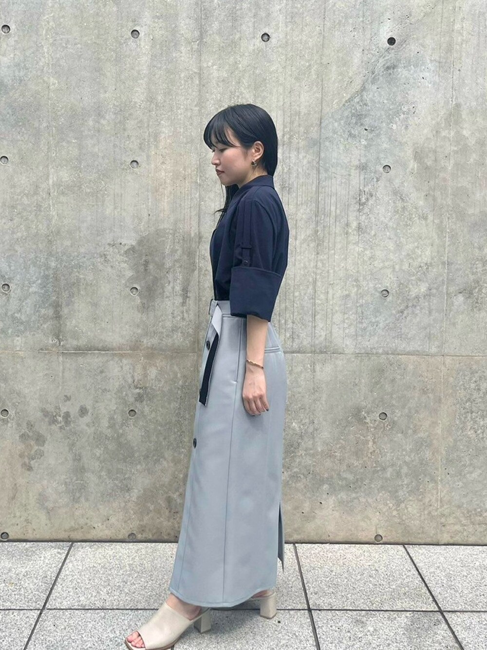 ブルー系のシャツ/ブラウス、グレー系のスカートを着用したレディースの春コーディネートの2枚目の写真