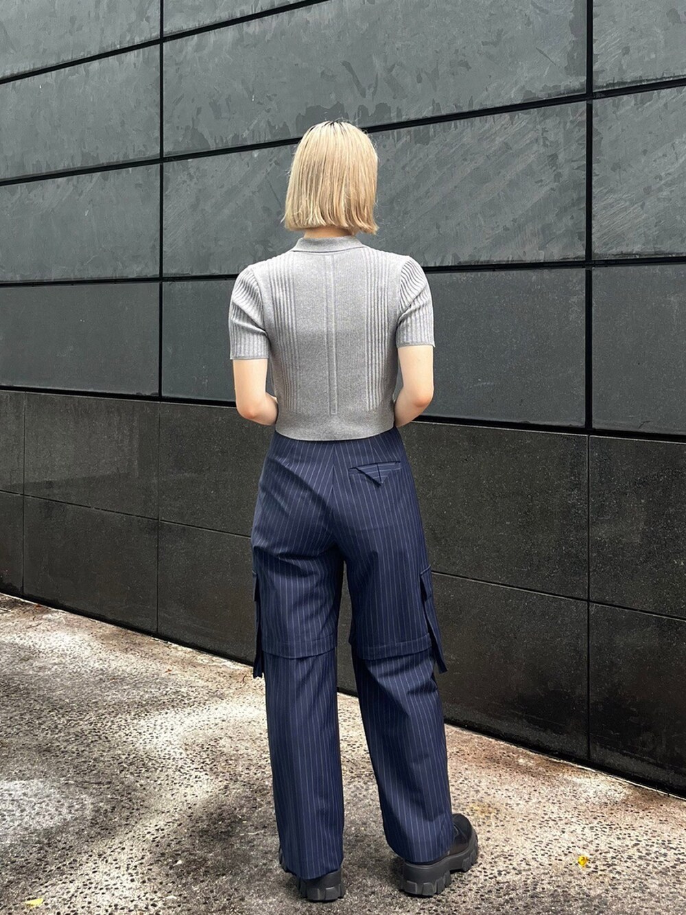 グレー系のポロシャツ、ブルー系のカーゴパンツを着用したレディースの夏コーディネートの3枚目の写真