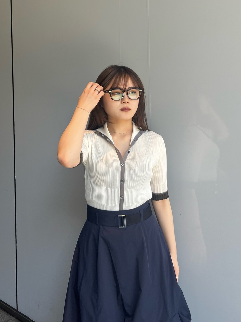 ホワイト系のニット/セーター、ブルー系のスカートを着用したレディースの夏コーディネートの3枚目の写真