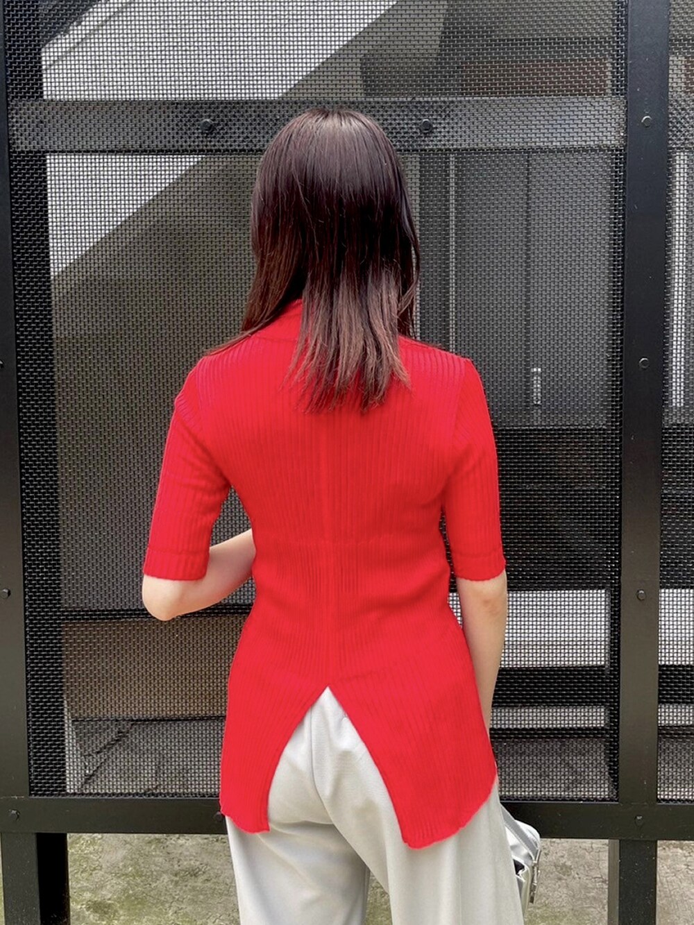 グレー系のその他パンツ、レッド系のニット/セーターを着用したレディースの春コーディネートの6枚目の写真