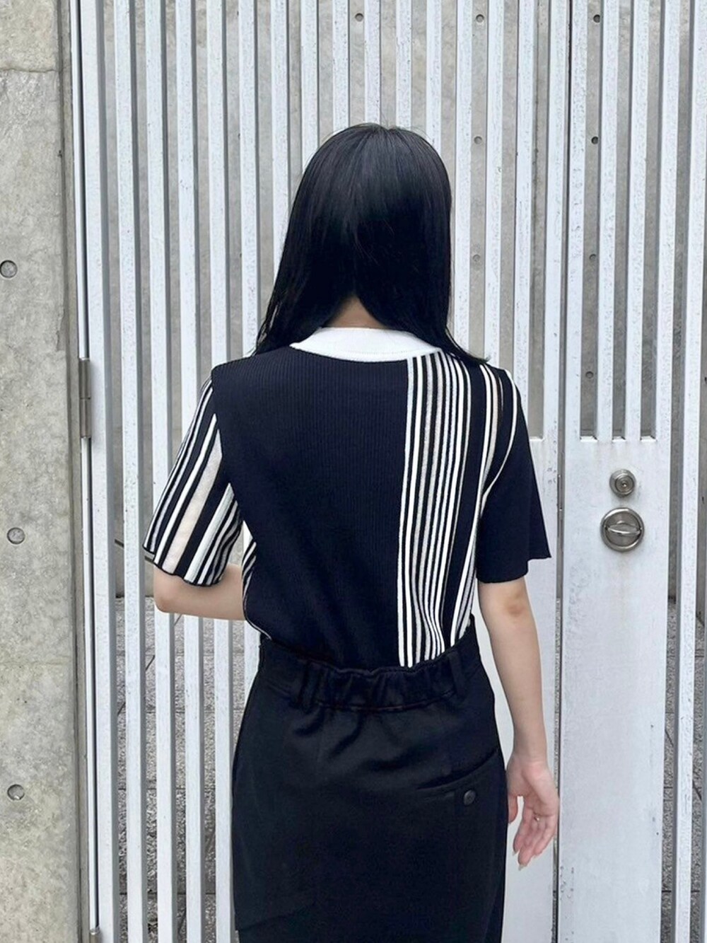 ブラック系のニット/セーター、ブラック系のスカートを着用したレディースの春コーディネートの6枚目の写真