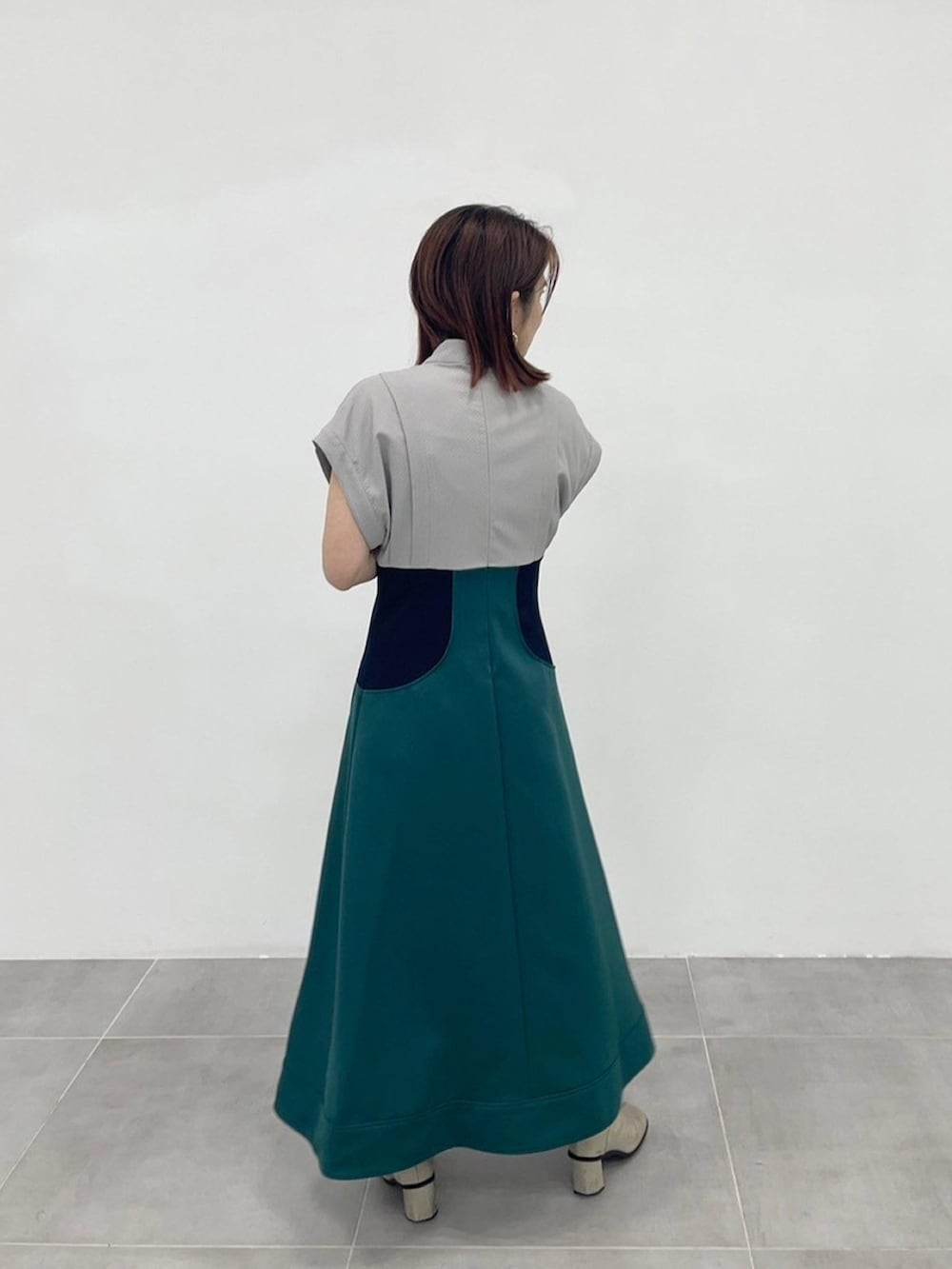 グリーン系のワンピースを着用したレディースの春コーディネートの3枚目の写真