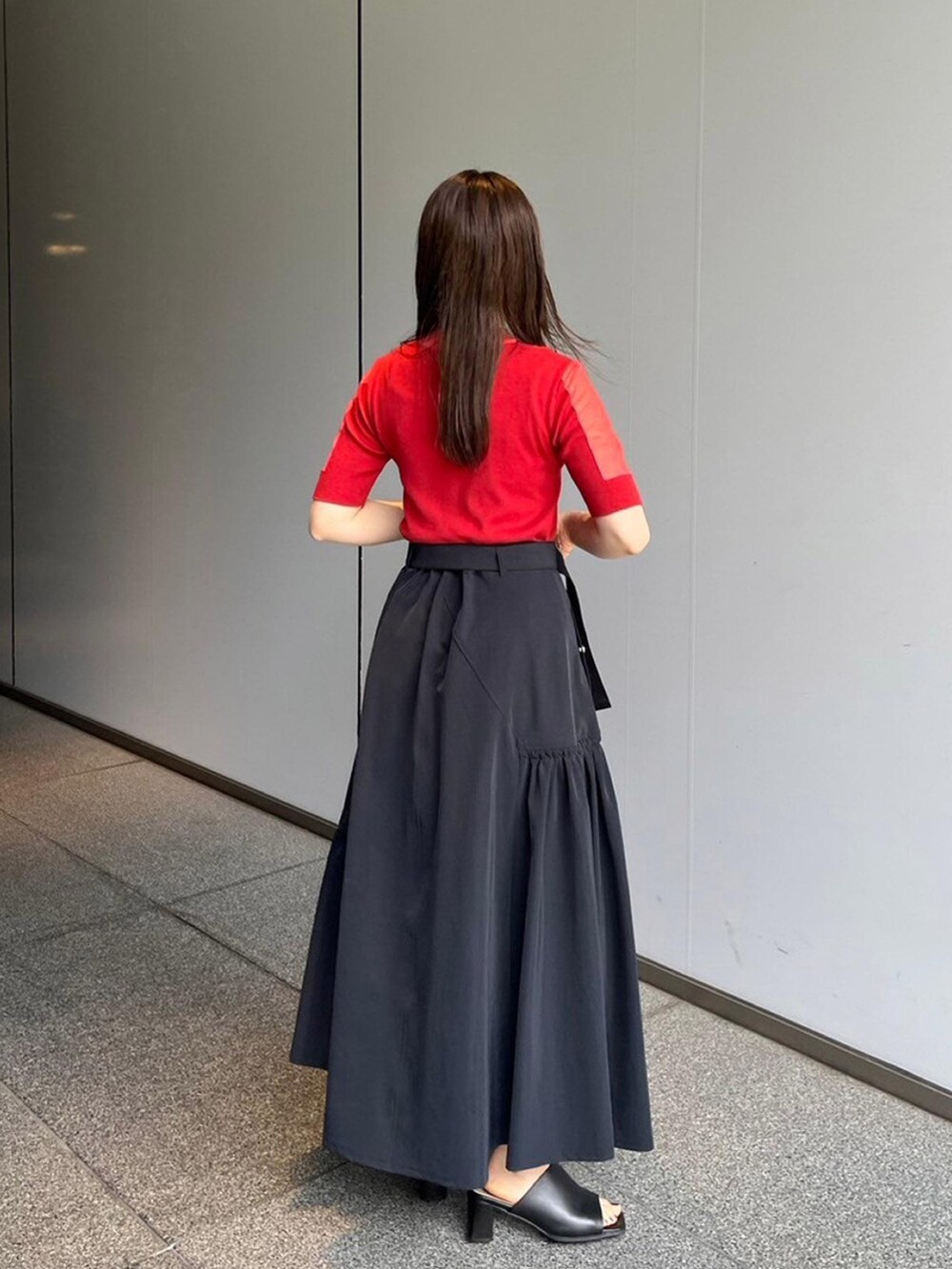 レッド系のニット/セーター、ブラック系のスカートを着用したレディースの夏コーディネートの3枚目の写真