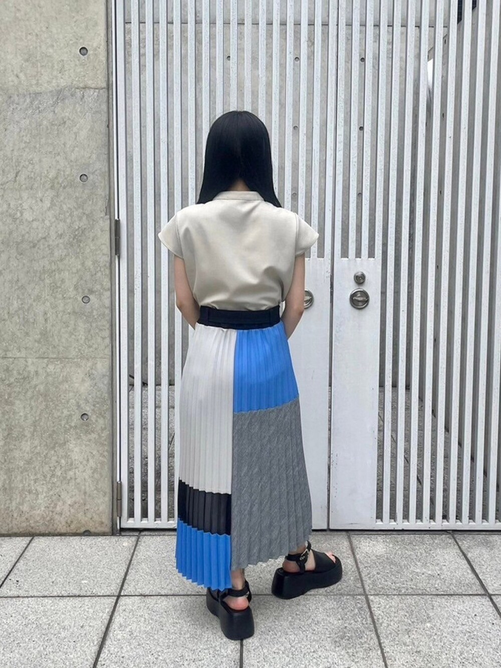 ベージュ系のシャツ/ブラウス、ブルー系のスカートを着用したレディースの春コーディネートの3枚目の写真