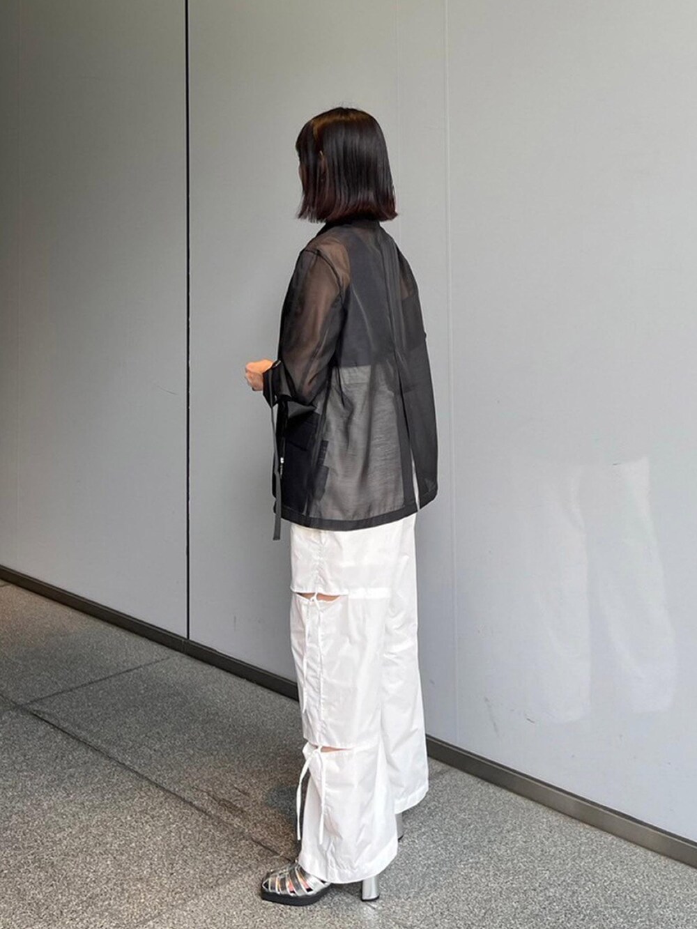 ブラック系のテーラードジャケット、ホワイト系のその他パンツ、ブルー系のタンクトップを着用したレディースの夏コーディネートの2枚目の写真