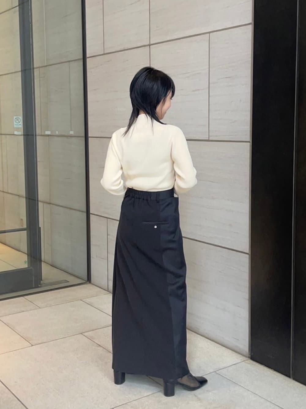 ベージュ系のニット/セーター、ブラック系のスカートを着用したレディースの春コーディネートの3枚目の写真