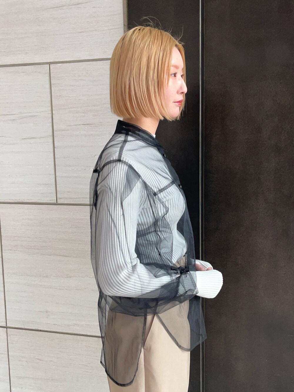 ブラック系のシャツ/ブラウス、ホワイト系のニット/セーター、ベージュ系のその他パンツを着用したレディースの春コーディネートの8枚目の写真