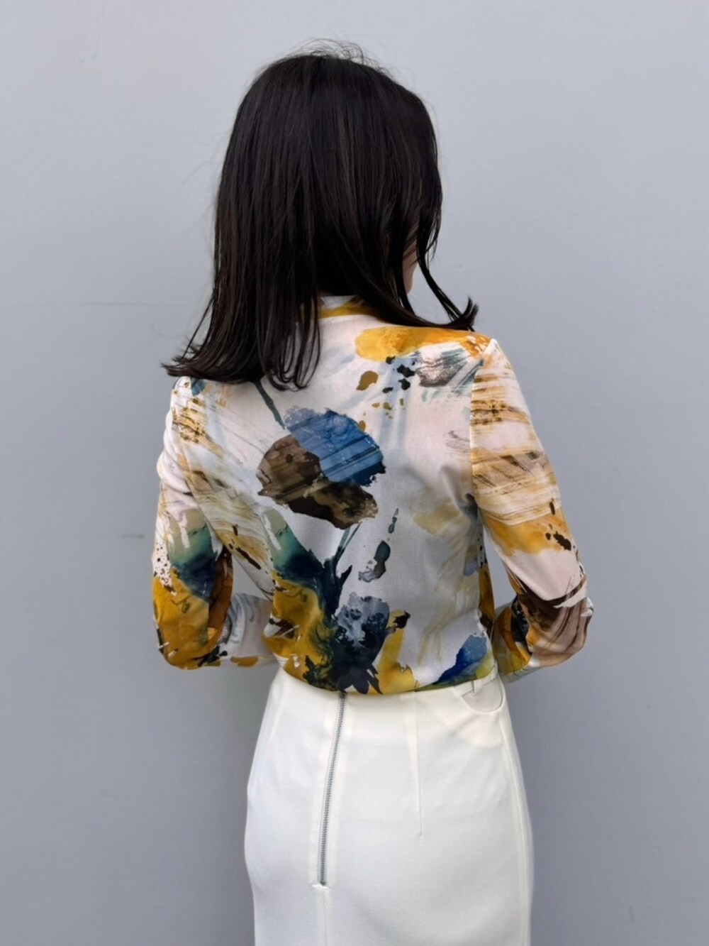 イエロー系のTシャツ/カットソー、ホワイト系のスカートを着用したレディースの冬コーディネートの6枚目の写真