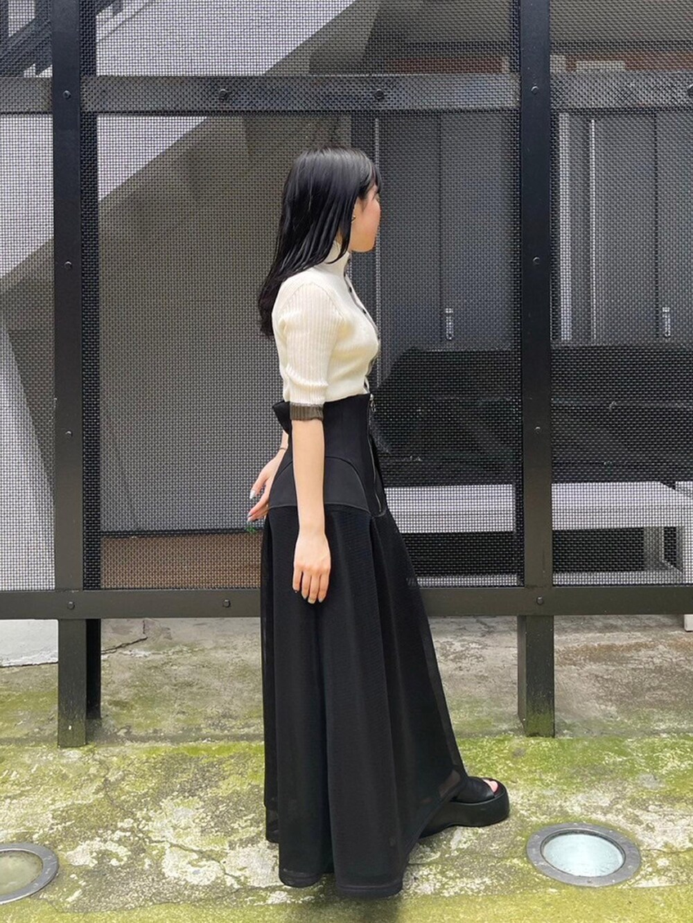 ブラック系のスカート、ホワイト系のニット/セーターを着用したレディースの春コーディネートの2枚目の写真