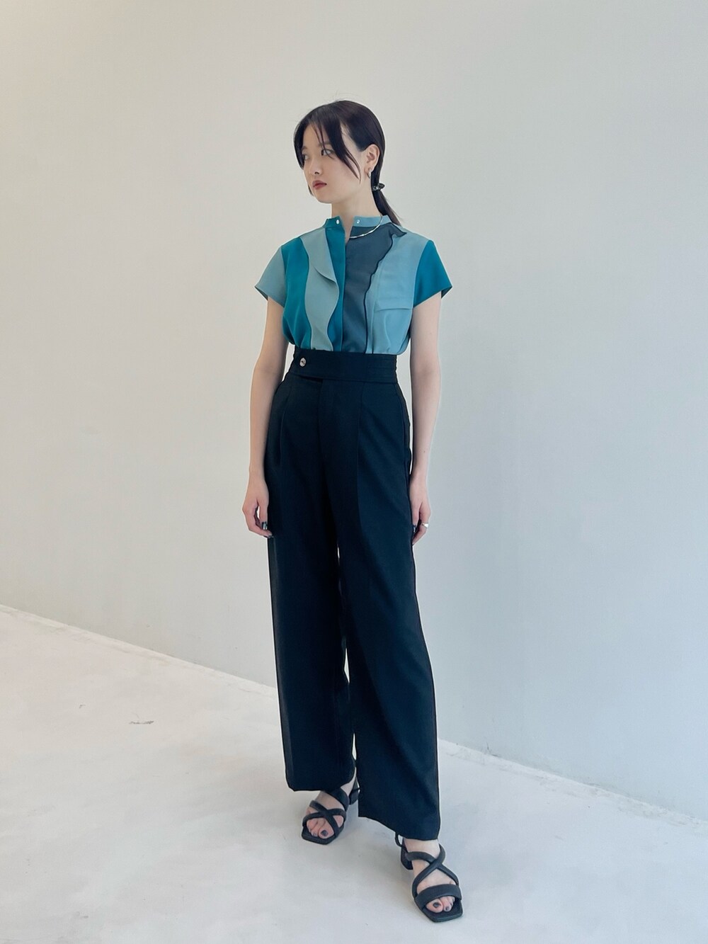 グリーン系のシャツ/ブラウス、ブラック系のスラックスを着用したレディースの夏コーディネートの2枚目の写真