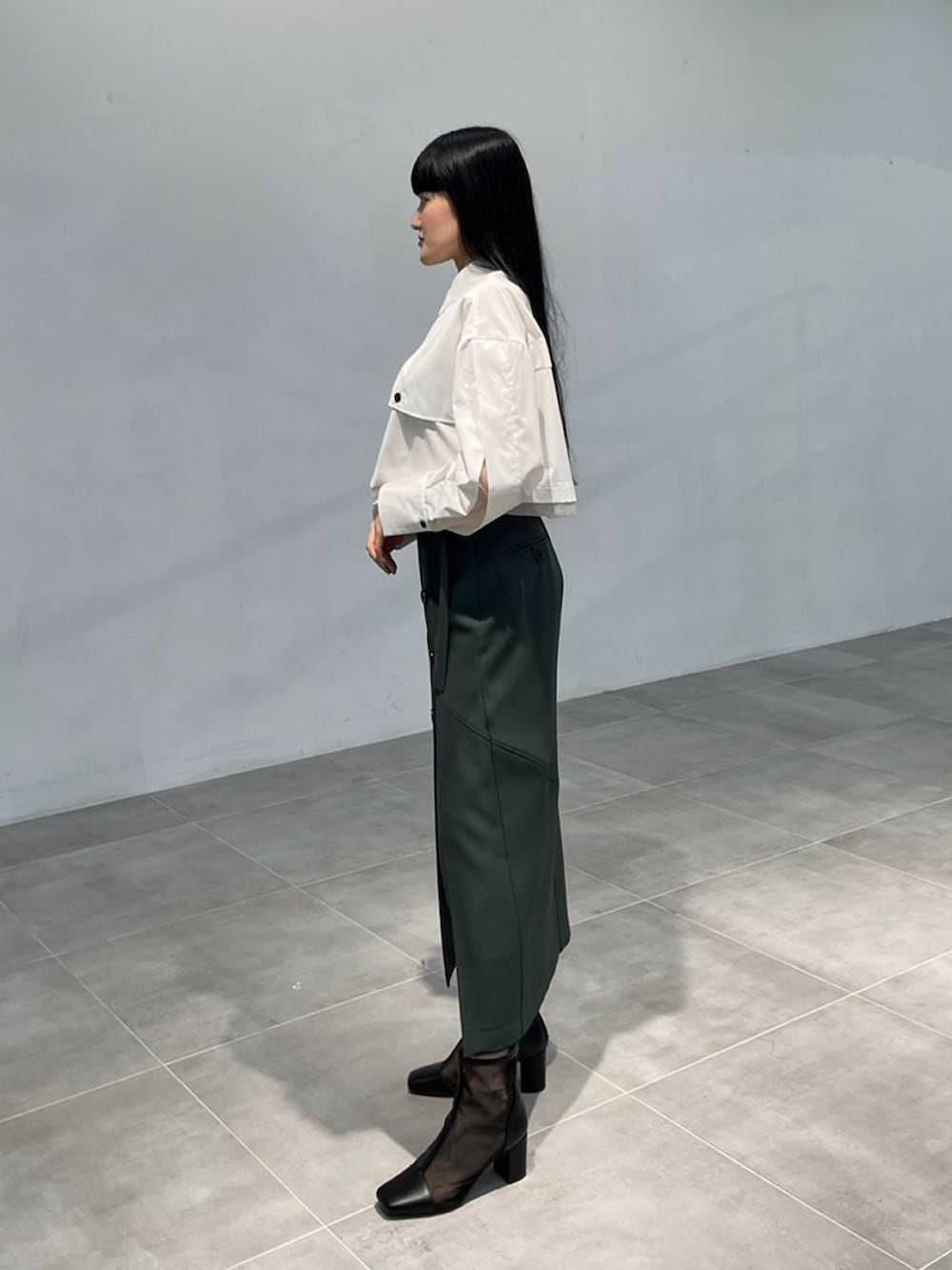 ホワイト系のシャツ/ブラウス、グリーン系のスカートを着用したレディースの秋コーディネートの2枚目の写真