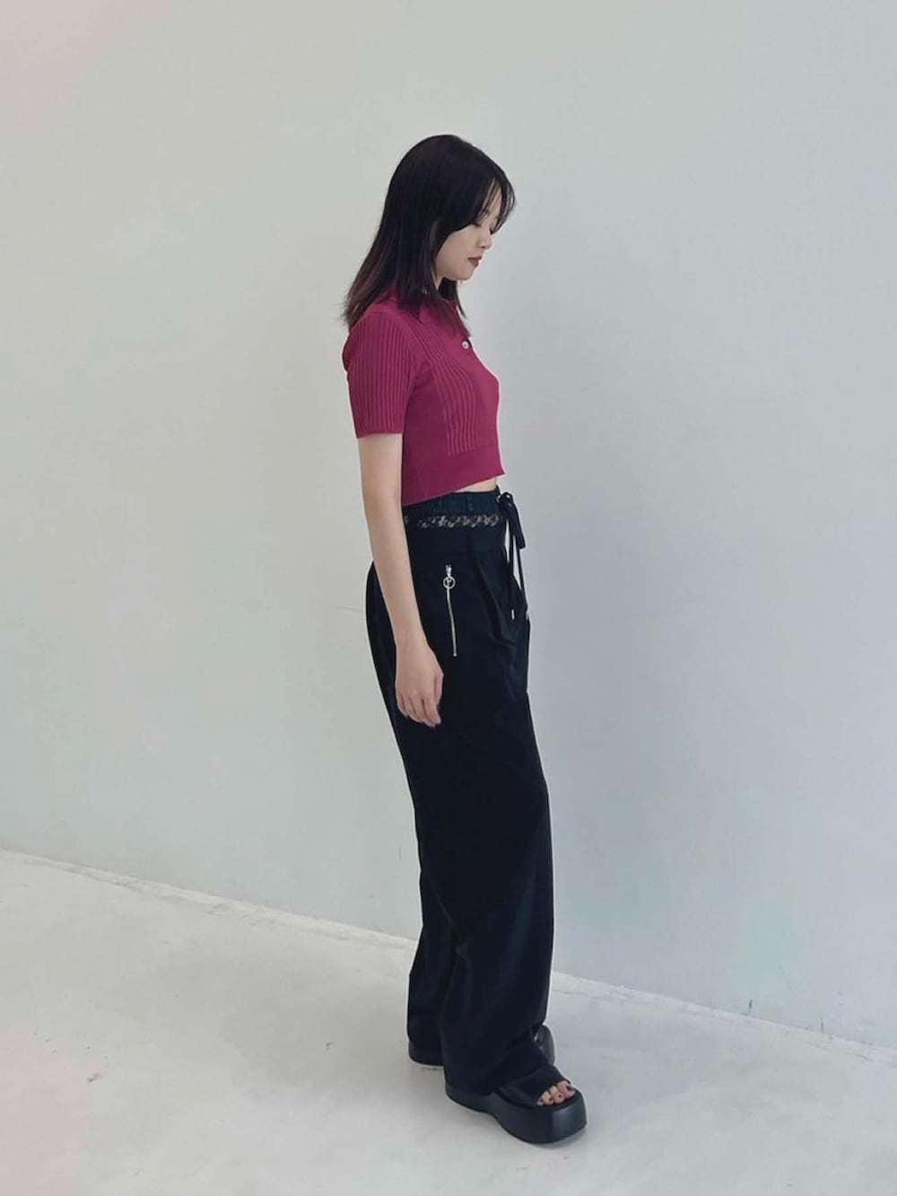 ピンク系のポロシャツ、ブラック系のその他パンツを着用したレディースの夏コーディネートの2枚目の写真