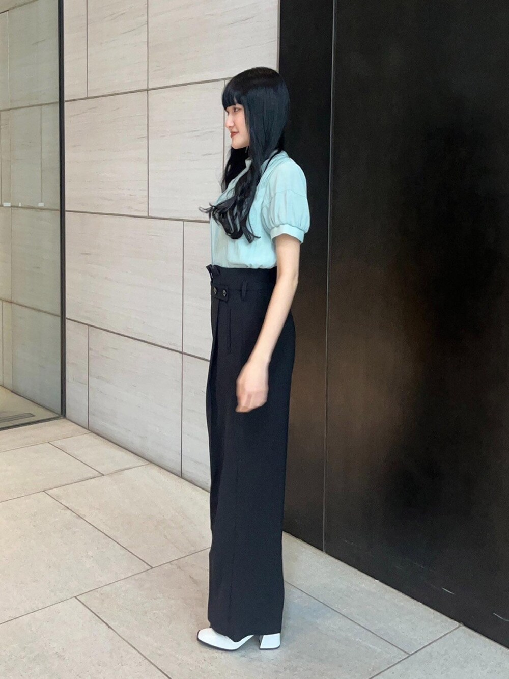 ブラック系のスラックス、グリーン系のシャツ/ブラウスを着用したレディースの春コーディネートの2枚目の写真