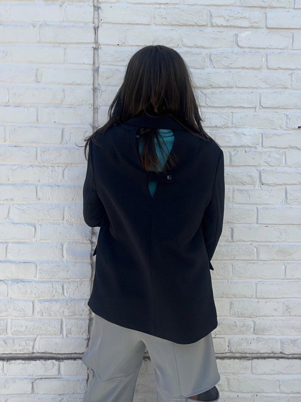 ブラック系のテーラードジャケットを着用したレディースの春コーディネートの6枚目の写真