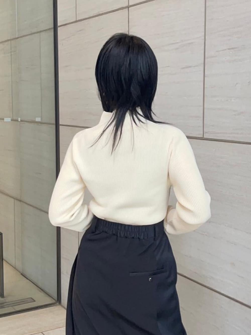 ベージュ系のニット/セーター、ブラック系のスカートを着用したレディースの春コーディネートの6枚目の写真