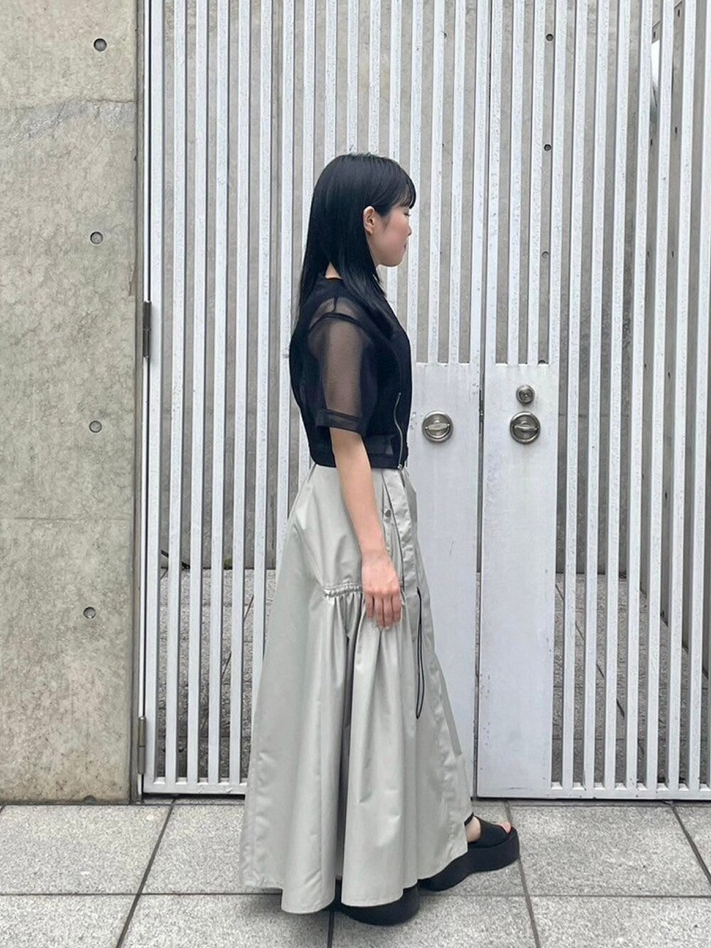 ブラック系のシャツ/ブラウス、ベージュ系のスカート、ブラック系のタンクトップを着用したレディースの春コーディネートの4枚目の写真