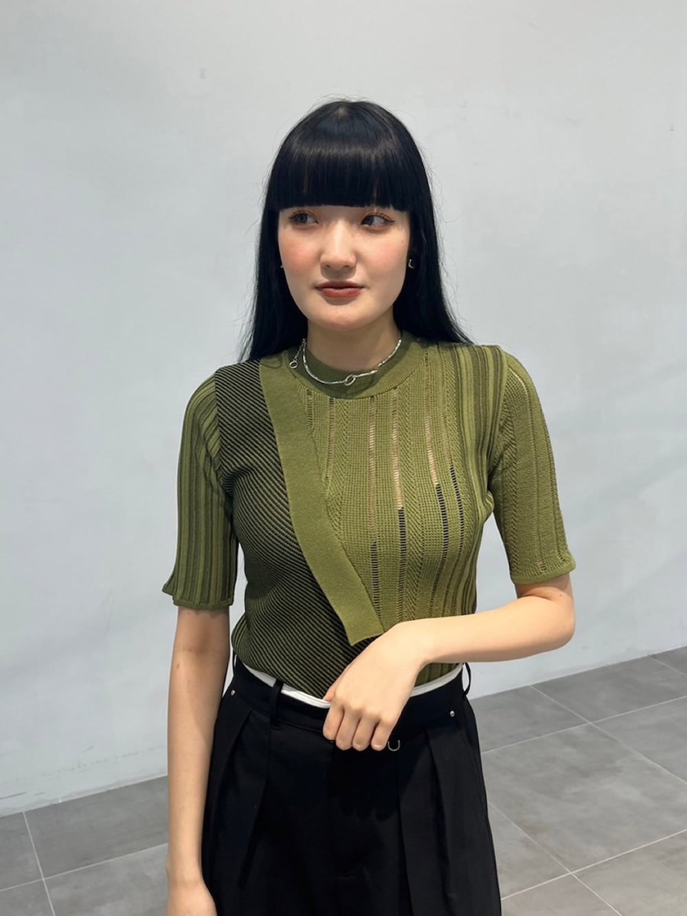 グリーン系のニット/セーター、ブラック系のその他パンツを着用したレディースの秋コーディネートの4枚目の写真