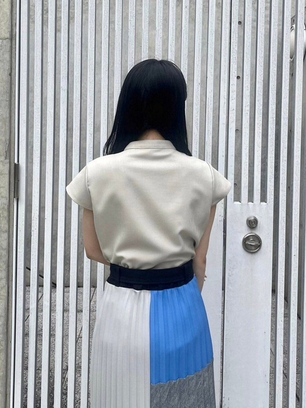 ベージュ系のシャツ/ブラウス、ブルー系のスカートを着用したレディースの春コーディネートの6枚目の写真