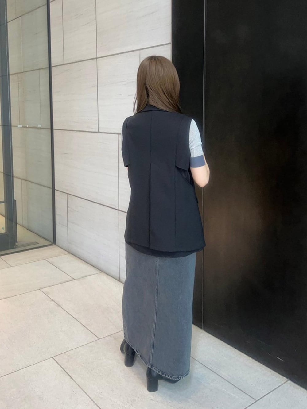 ブラック系のベストを着用したレディースの春コーディネートの3枚目の写真