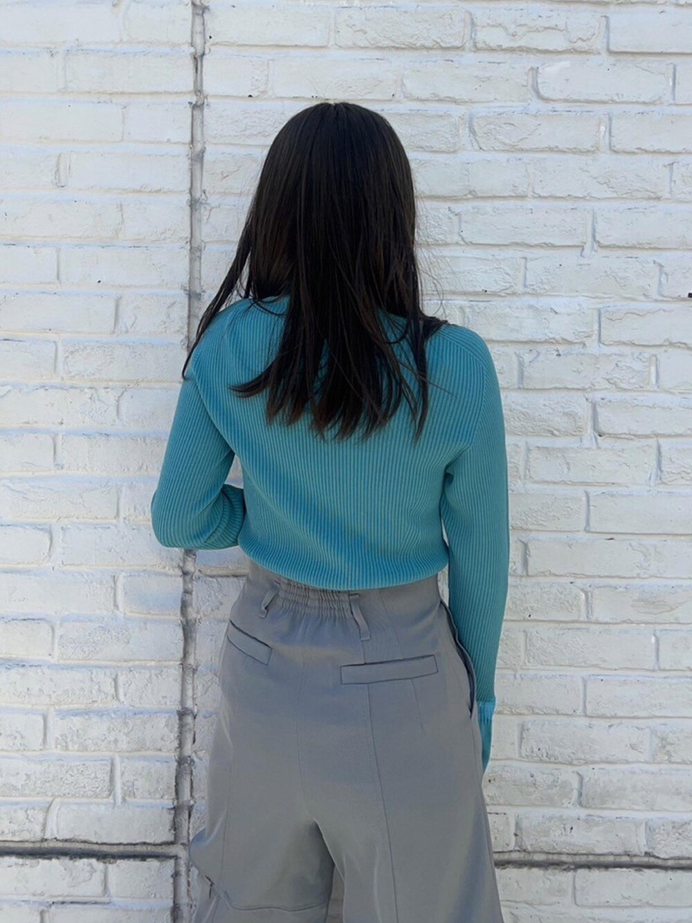 ブルー系のニット/セーター、グレー系のその他パンツを着用したレディースの春コーディネートの6枚目の写真