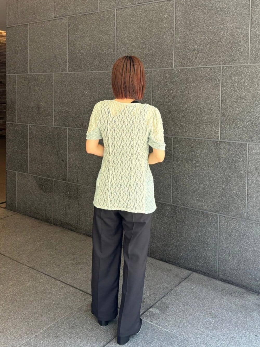 グリーン系のTシャツ/カットソー、ブラック系のスラックス、ブラック系のタンクトップを着用したレディースの夏コーディネートの3枚目の写真