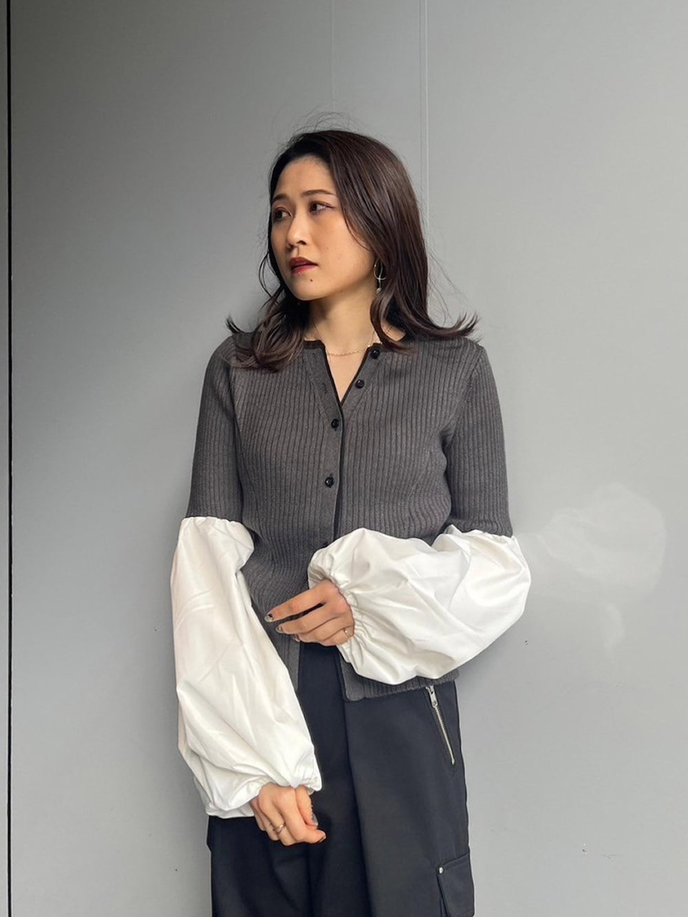 グレー系のニット/セーター、ブラック系のカーゴパンツを着用したレディースの秋コーディネートの3枚目の写真