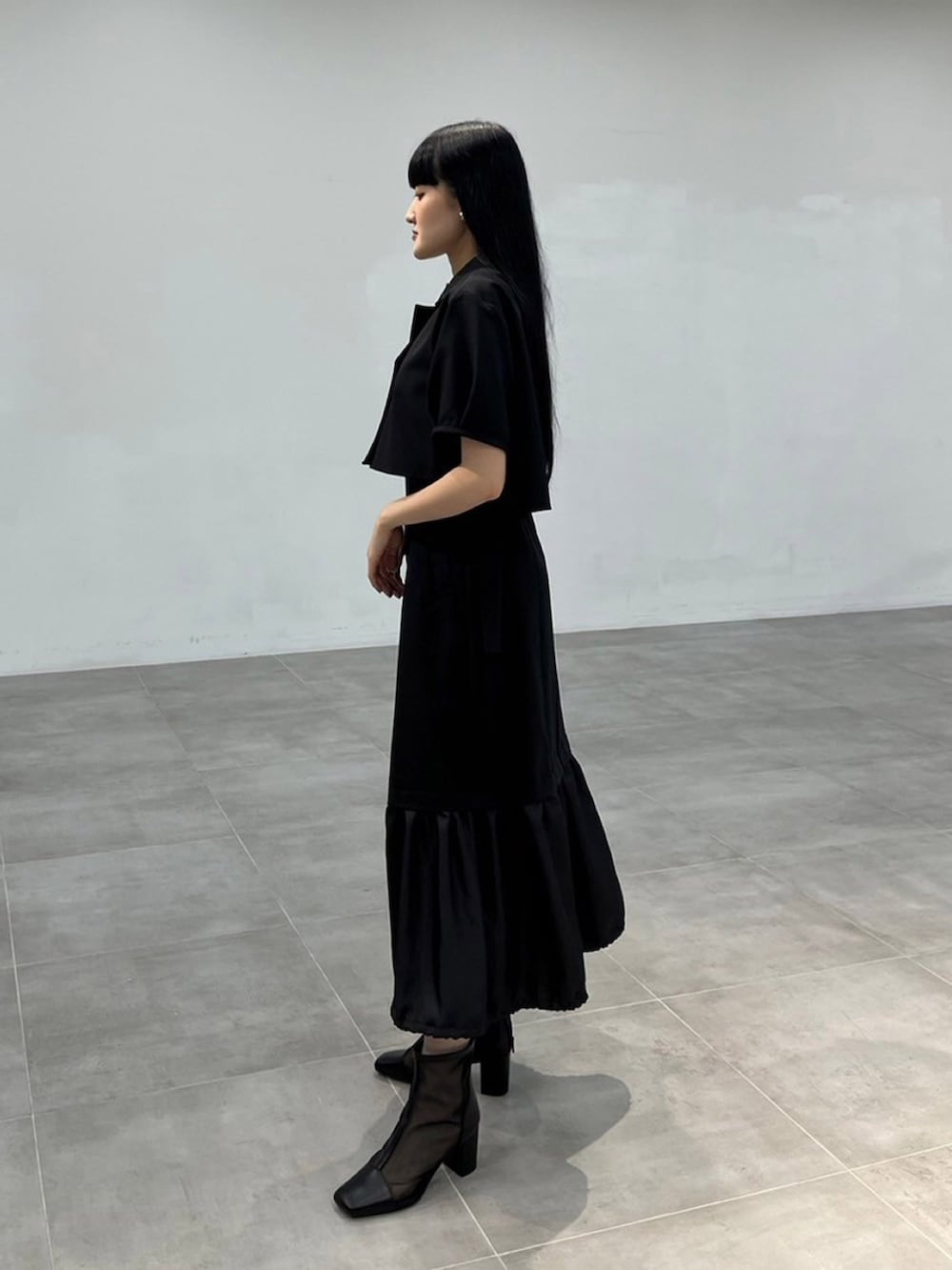 ブラック系のワンピースを着用したレディースの秋コーディネートの2枚目の写真