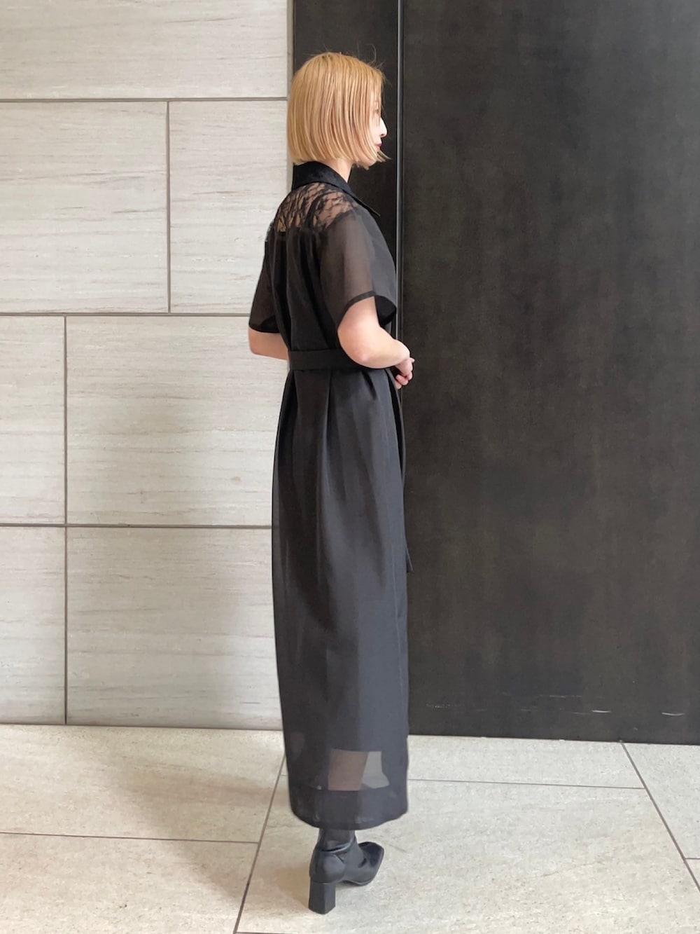 ブラック系のシャツワンピースを着用したレディースの春コーディネートの4枚目の写真