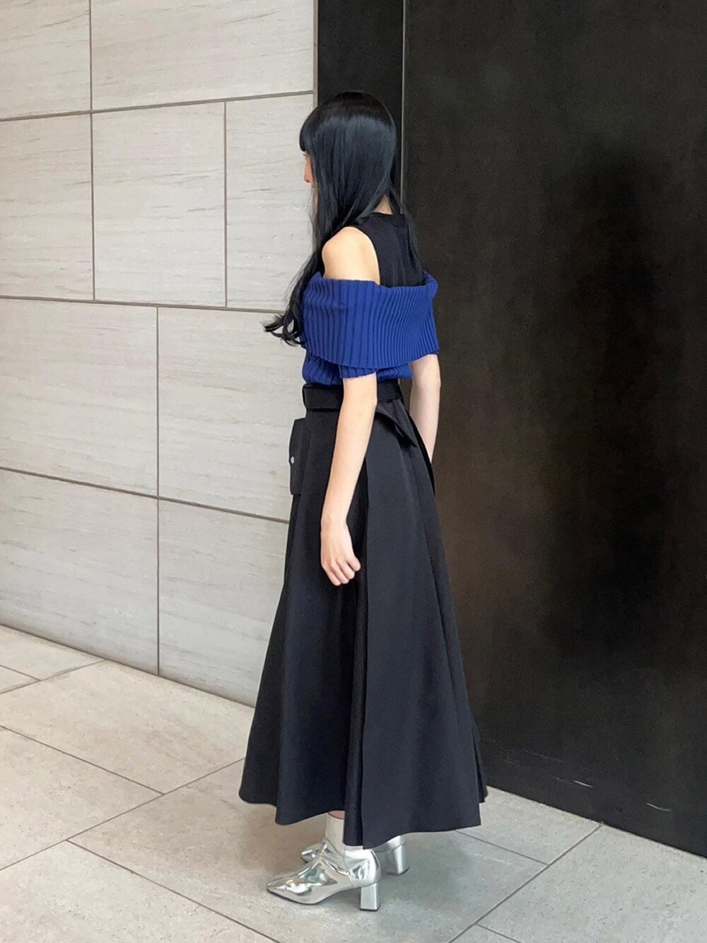 ブラック系のスカート、ブルー系のニット/セーターを着用したレディースの春コーディネートの2枚目の写真